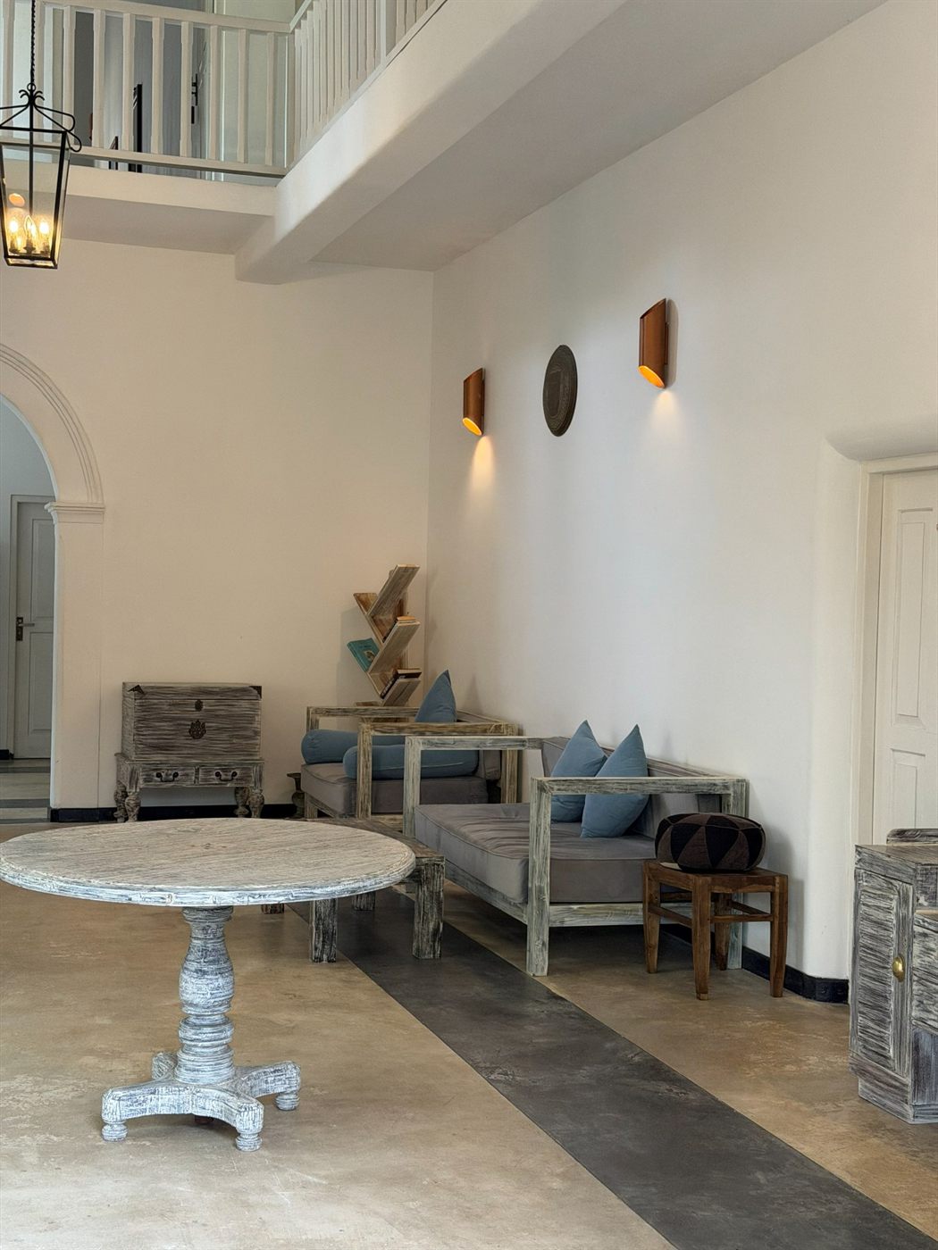 The whole villa — the shared double-height living hall with sofas and hanging lanterns